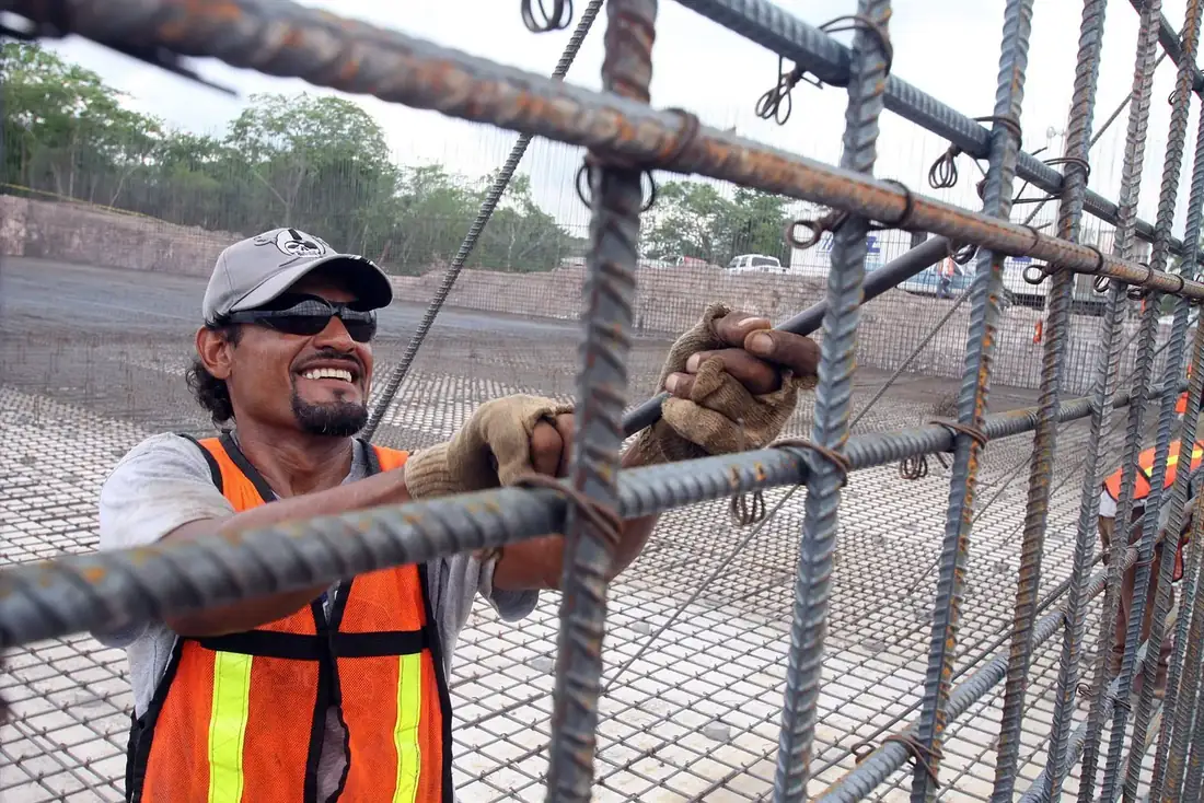 Construction worker securing steel rebar